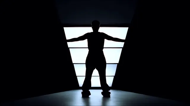 Dancer in silhouette framed by a brightly illuminated geometric doorway